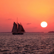 Le jour où le bateau viendra - Photo d'un voilier navigant au coucher de soleil